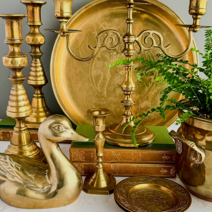 A collection of brass trays, dishes, and candlesticks