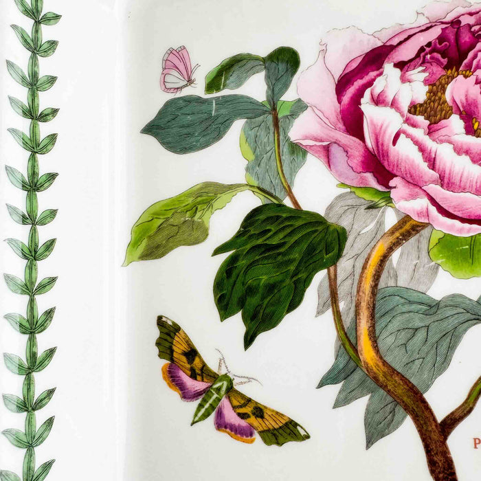 Close-up of left side of baking dish showing vine border and two butterfiles