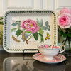 Styled view of Portmeirion baking dish displayed with teacup and rose bouquet