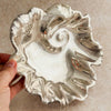 Silver ruffled bowl held by a hand