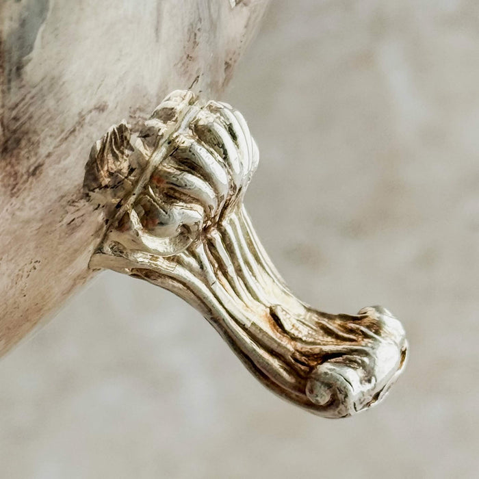 Close-up of decorative foot on silver ruffled bowl