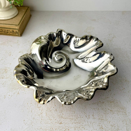 Angled view of vintage silver plate bowl showing the sculpted shell-like interior and ruffled rim