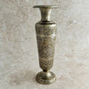 Decorative engraved bud vase with intricate patterns on a beige background