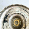 Underside of the vintage brass vase showing worn silver-colored finish, exposed brass, and stamped markings.