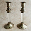 Two silver and lucite candle holders on a beige surface