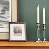 Vintage silver and lucite candle holders styled on a mantel with framed artwork for simple winter home decor