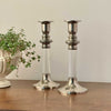 Pair of vintage silverplate and clear lucite candlestick holders, styled on a wood surface with trailing plant