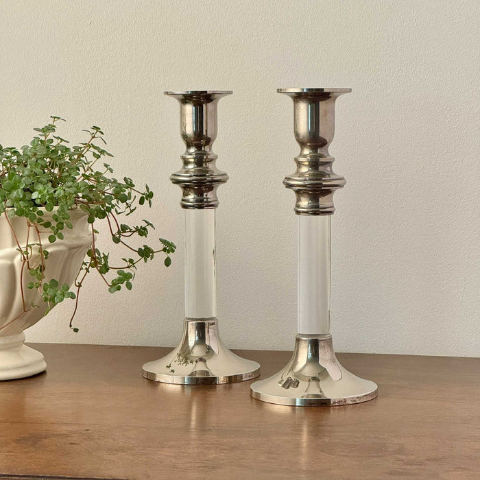 Pair of vintage silverplate and clear lucite candlestick holders, styled on a wood surface with trailing plant