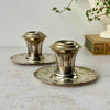Pair of vintage silverplate candlestick holders with low scalloped bases, flared stems, and geometric Art Deco decoration.