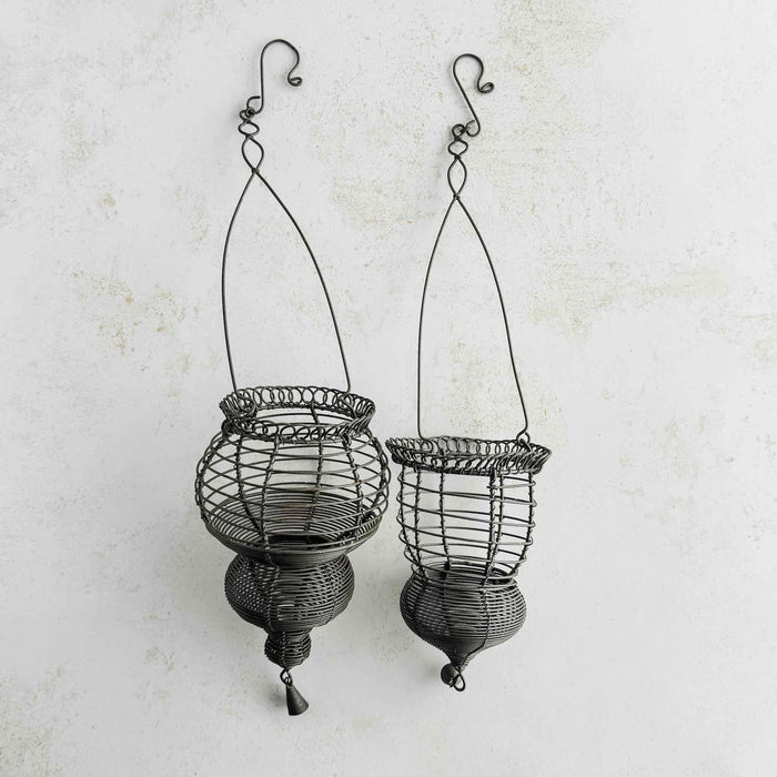Profile view of hanging wire baskets side by side on a light background