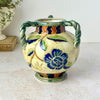 Vintage Maruhon Ware triple-handled vase with blue floral motif, green twisted handles, multicolor border, and beige ground