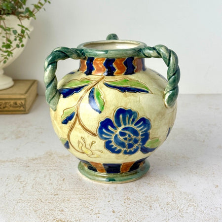 Vintage Maruhon Ware triple-handled vase with blue floral motif, green twisted handles, multicolor border, and beige ground