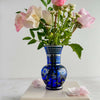 Cobalt blue and silver vase styled with flowers against a light background