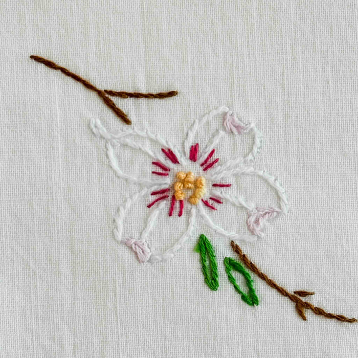 Close-up of individual embroidered flower on pillowcase