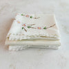 Stacked folded embroidered pillowcases - angled view