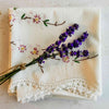 Stacked folded embroidered pillowcases styled with lavender