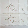 Unfolded pillowcases showing floral embroidery and crochet edges