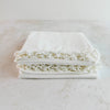 Stacked folded pillowcases showing lace edging - angled top down view