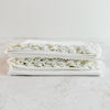 Stacked folded pillowcases showing lace edging - end view