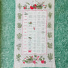 Full view of tea towel spread out on a teal formica table top