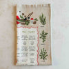 Folded tea towel showing upper right border illustrations