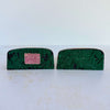 Undersides of vintage cast iron duck bookends showing worn green felt and retailer sticker reading "The Book Shop, 316 No. Chicago St., Joliet, ILL"
