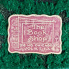 Close-up of retailer sticker reading "The Book Shop, 316 No. Chicago St., Joliet, ILL" on green felt
