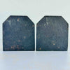 Backs of vintage cast iron duck bookends showing textured iron surface and partially legible stamped maker's mark and model number 1003