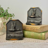 Pair of vintage duck bookends with raised flying duck design and dark aged finish, styled with antique books and trailing plant