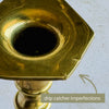 Close-up of a brass drip catcher with a hexagonal flange showing minor imperfections on the surface, with a text overlay and pointing arrow