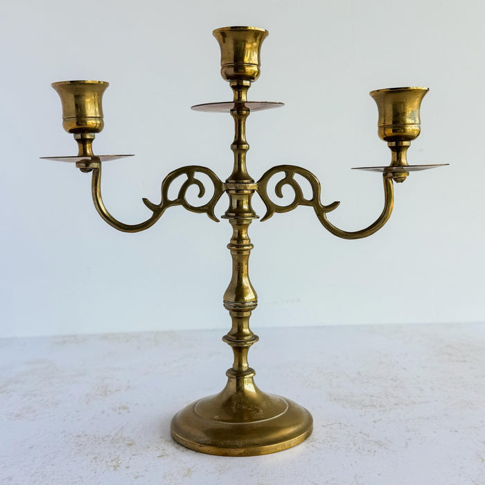 Vntage mid-century 3-candle brass candelabra against a light background