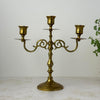 Vintage brass three-arm candelabra with scrolled arms and round pedestal base