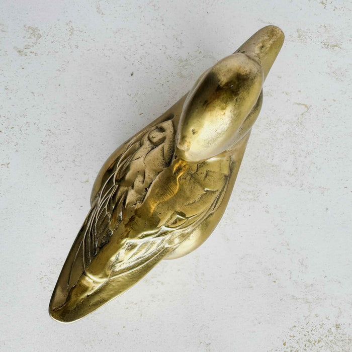 Top view of vintage brass duck figurine showing body shape, wing details, and elongated form