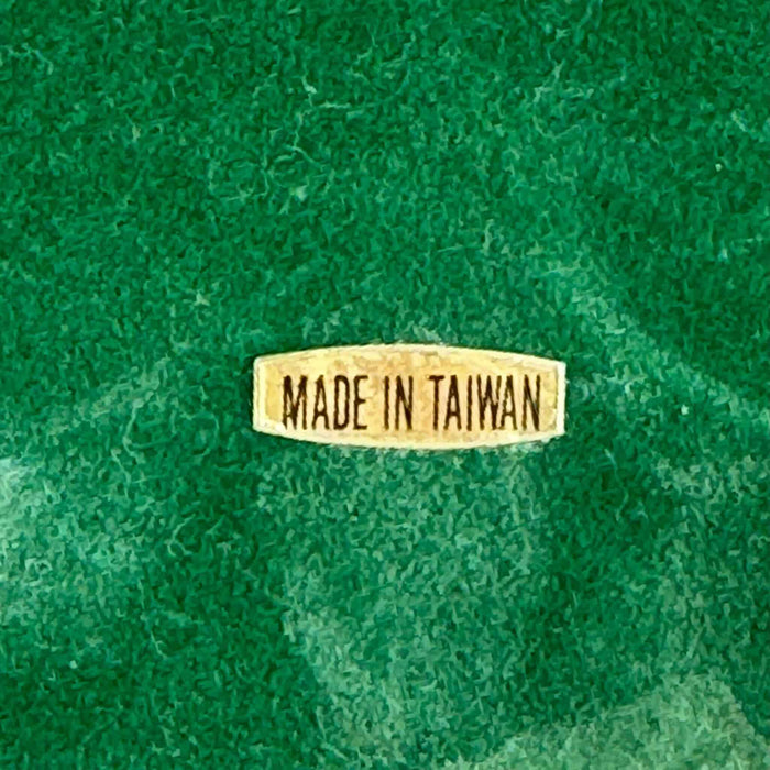 Close-up of underside label reading Made in Taiwan on green flocked base