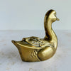 Angled back view of brass duck figurine showing carved-style feather details on wings and tail