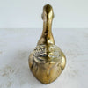Back view of vintage brass duck figurine showing narrow profile, head shape, and wing detailing
