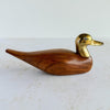 Wood and brass duck against a light background
