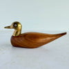 Wood and brass duck against a light background
