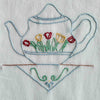 Close-up of blue teapot embroidery