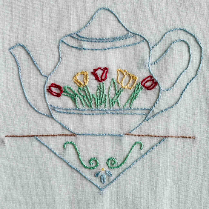 Close-up of blue teapot embroidery