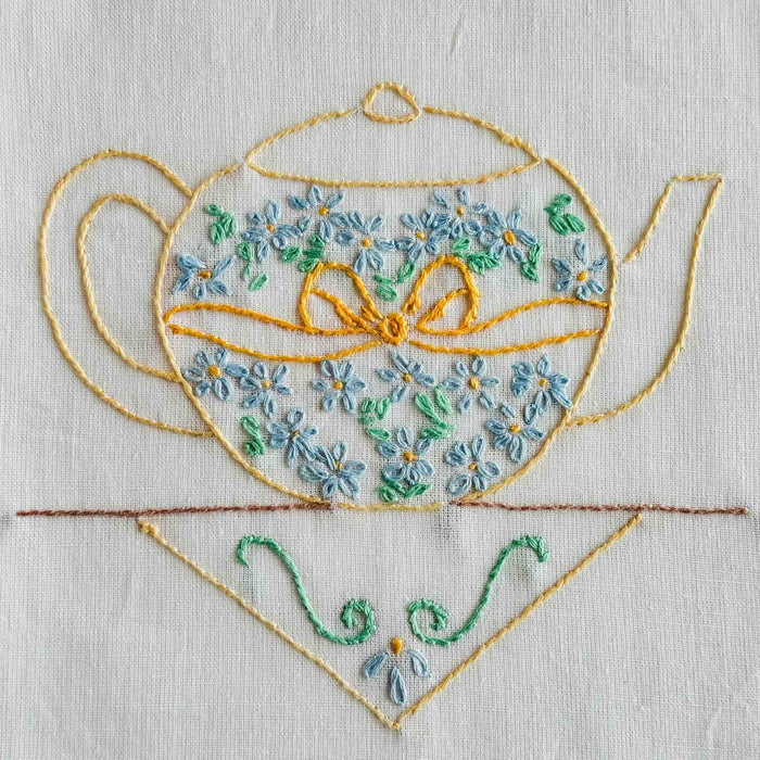 Close-up of yellow teapot embroidery