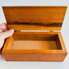 Inlaid wood box with hand holding lid open