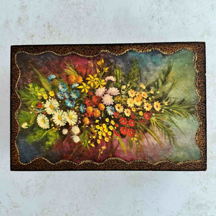 Top down view of vintage floral wood keepsake box lid decorated with flowers and wavy border