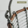 Close-up of the basket rim showing a natural twig incorporated into the wire structure, labeled “twig rim detail.”