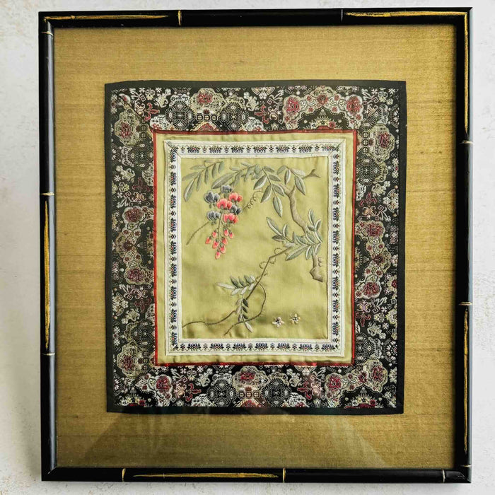 Framed embroidered fabric with floral and butterfly design on a light background