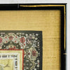 Close-up of corner of black and gold bamboo frame and gold silk texture mat