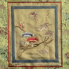 Close-up of embroidered panel with floral and leaf design on a pale gold fabric 