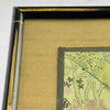 Close-up of corner of black and gold bamboo frame and gold silk texture mat