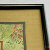 Close-up of corner of black and gold bamboo frame and gold silk texture mat