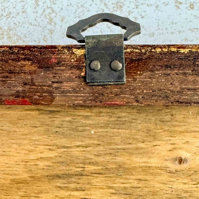 Close up of metal hanging loop on back of framed Italian art 